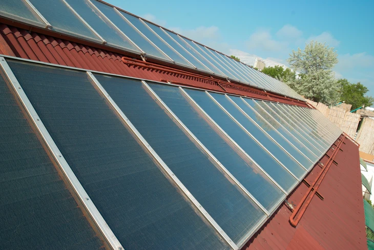 Toit carrelé rouge d'une maison résidentielle avec panneaux solaires installés
