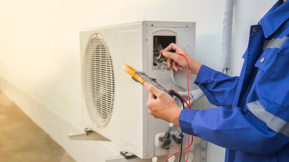 Intérieur résidentiel avec personne utilisant une caméra thermique infrarouge pour analyser les déperditions de chaleur près d'une fenêtre